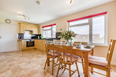 a kitchen and dining room with a wooden table and chairs at 4 Bed in Padstow oc-p00401 in Padstow