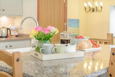 a kitchen counter with a tray with flowers and cups at 3 Bed in Bodmin oc-p00437 in Bodmin