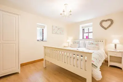 a white bedroom with a crib and two windows at 3 Bed in Bodmin oc-p00437 in Bodmin