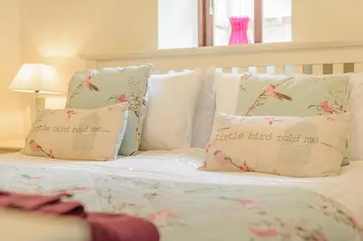 a bed with white sheets and pillows with birds on it at 3 Bed in Bodmin oc-p00437 in Bodmin