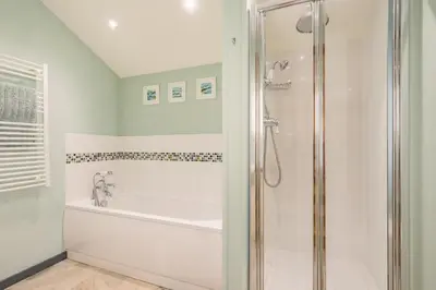 a white bathroom with a shower and a tub at 3 Bed in Bodmin oc-p00437 in Bodmin
