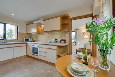 a kitchen with a table and a vase of flowers at 1 Bed in Wadebridge oc-p00440 in Saint Issey