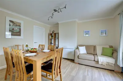 a dining room with a table and a couch at 2 Bed in Padstow oc-p00464 in St Merryn