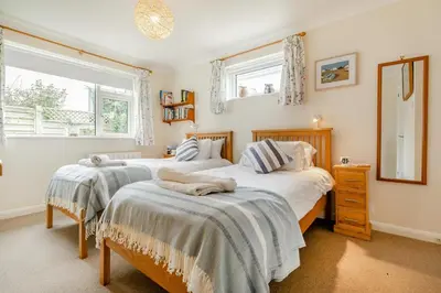 two beds in a bedroom with two windows at 3 Bed in Padstow oc-p00435 in Padstow