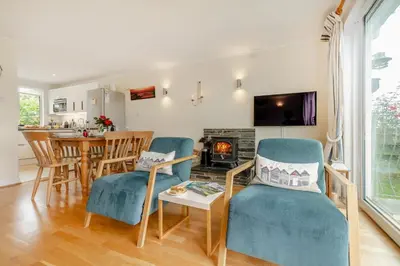a living room with chairs and a table and a fireplace at 3 Bed in Padstow oc-p00435 in Padstow
