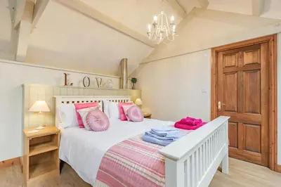 a bedroom with a white bed with pink pillows at 1 Bed in Bodmin oc-p00438 in Bodmin