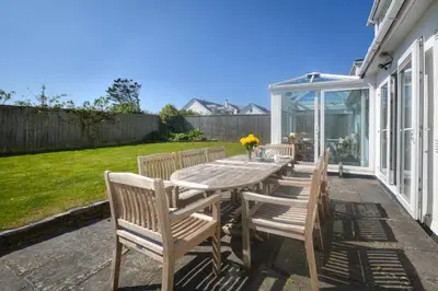 a wooden table and chairs on a patio at 4 Bed in Padstow oc-p00425 in St Merryn