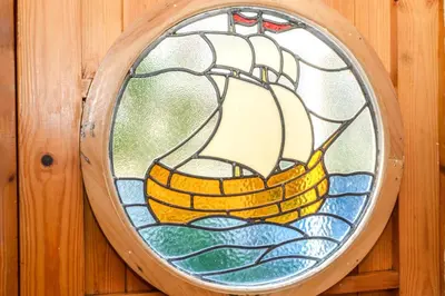 a stained glass window of a ship in the water at 3 Bed in Newquay oc-p00484 in Newquay