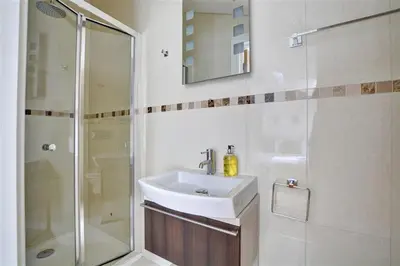 a white bathroom with a sink and a shower at 3 Bed in Wadebridge oc-p00415 in Saint Issey