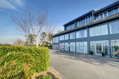 a building with windows and a hedge in front of it at 3 Bed in Wadebridge oc-p00415 in Saint Issey