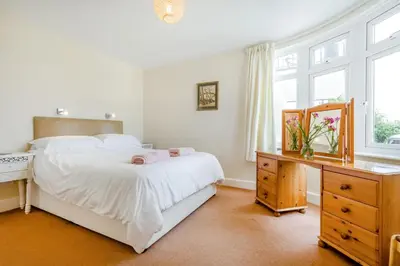 a bedroom with a bed and a desk and windows at 1 Bed in Padstow oc-p00485 in St Merryn