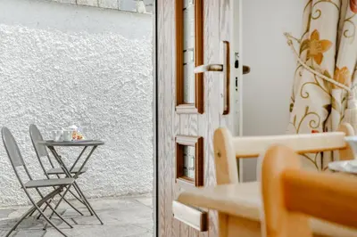 a small table and chair next to a door at 1 Bed in Padstow oc-p00485 in St Merryn