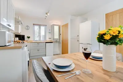 a kitchen with a wooden table with a vase of flowers at 2 Bed in Padstow oc-p00481 in Padstow