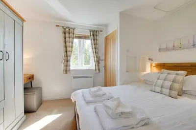 a bedroom with a white bed with towels on it at 2 Bed in Padstow oc-p00481 in Padstow