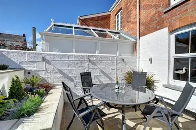 a patio with a table and chairs in front of a building at 3 Bed in Padstow oc-p00455 in Padstow