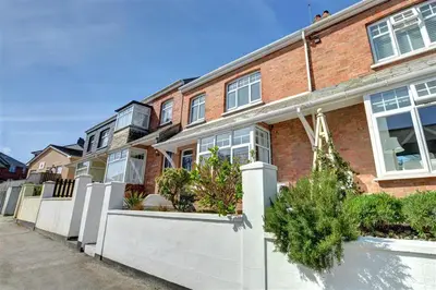 a red brick building with white fences and plants at 3 Bed in Padstow oc-p00455 in Padstow