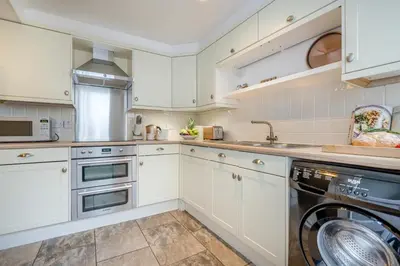 a kitchen with white cabinets and a dishwasher at 3 Bed in Padstow oc-p00455 in Padstow