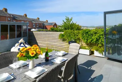 a table with a vase of flowers on a patio at 3 Bed in Padstow oc-p00504 in Padstow