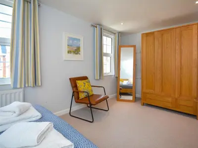 a bedroom with a bed and a chair and a mirror at 3 Bed in Padstow oc-p00504 in Padstow