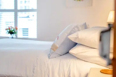 a white bed with white pillows and a window at 2 Bed in Padstow oc-p00505 in Padstow