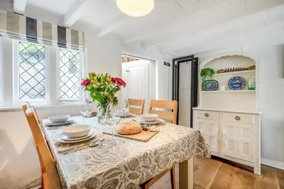 a dining room with a table with plates and flowers on it at 2 Bed in Padstow oc-p00509 in Padstow