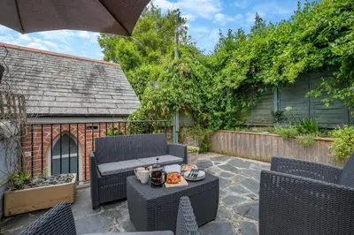 a patio with a table and chairs and an umbrella at 2 Bed in Padstow oc-p00509 in Padstow