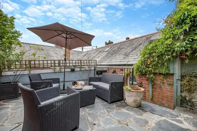 an outdoor patio with chairs and an umbrella at 2 Bed in Padstow oc-p00509 in Padstow
