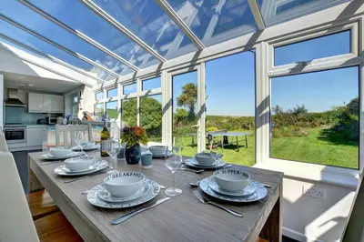 a dining room with a table with plates and wine glasses at 4 Bed in Padstow oc-p00528 in Padstow