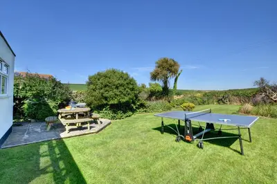 a ping pong table and picnic table on a lawn at 4 Bed in Padstow oc-p00528 in Padstow
