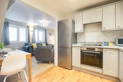 a kitchen with white cabinets and a table and chairs at 2 Bed in Padstow oc-p00531 in Padstow
