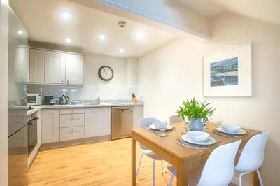 a kitchen and dining room with a wooden table and chairs at 2 Bed in Padstow oc-p00531 in Padstow