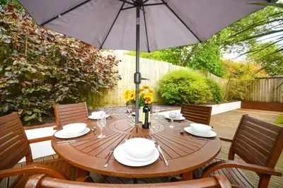 a wooden table with an umbrella on a patio at 3 Bed in St. Merryn oc-p00569 in St Merryn