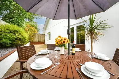 a wooden table with an umbrella on a patio at 3 Bed in St. Merryn oc-p00569 in St Merryn