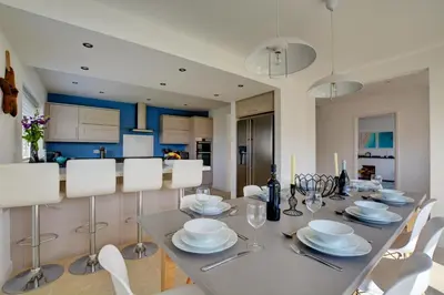 a dining room with a table with white chairs at 6 Bed in Constantine Bay oc-p00571 in St Merryn