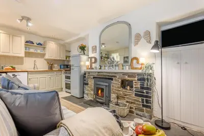 a kitchen and a living room with a fireplace at 2 Bed in Padstow oc-p00572 in Padstow