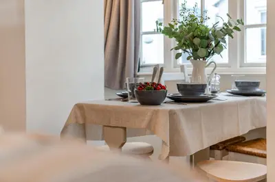 a table with plates and a vase of flowers on it at 2 Bed in Padstow oc-p00572 in Padstow
