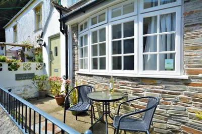 a patio with a table and chairs in front of a building at 2 Bed in Padstow oc-p00572 in Padstow