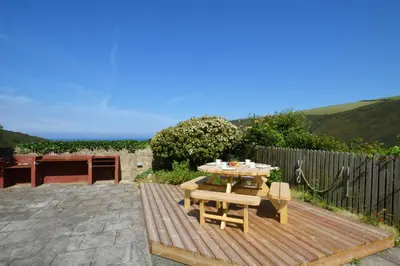 a wooden deck with a table and chairs on it at 2 Bed in Crackington Haven oc-p00596 in Crackington Haven