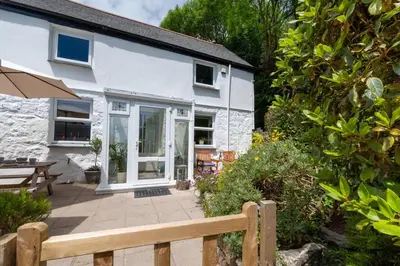 a white cottage with a patio in front of it at 2 Bed in Penzance oc-p00597 in Saint Erth
