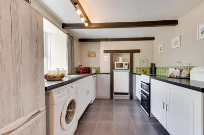a large kitchen with a washer and dryer at 2 Bed in Penzance oc-p00597 in Saint Erth