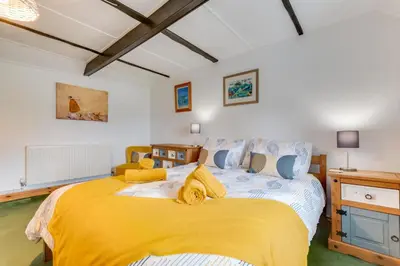 a bedroom with a large bed with yellow sheets at 2 Bed in Penzance oc-p00597 in Saint Erth