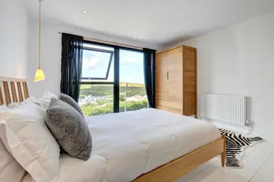 a bedroom with a large bed with a large window at 4 Bed in Mawgan Porth oc-p00608 in Mawgan Porth