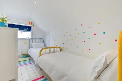 two beds in a bedroom with a wall covered in stickers at 4 Bed in Mawgan Porth oc-p00608 in Mawgan Porth