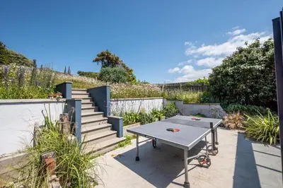 a patio with a table and some stairs at 4 Bed in Mawgan Porth oc-p00608 in Mawgan Porth