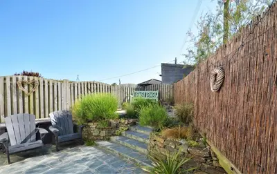 a garden with two chairs and a fence at 2 Bed in St. Merryn oc-p00607 in St Merryn