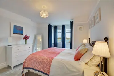 a bedroom with a bed and a dresser and a window at 5 Bed in Padstow oc-p00628 in Padstow