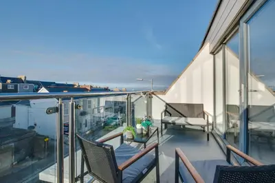 a balcony with chairs and a view of the ocean at 3 Bed in Newquay oc-p00631 in Newquay