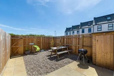a patio with a wooden fence and a table at 3 Bed in Newquay oc-p00631 in Newquay