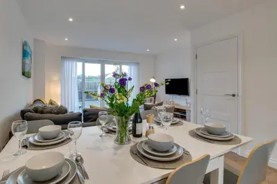 a dining room table with a vase of flowers on it at 3 Bed in Newquay oc-p00631 in Newquay