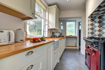 a kitchen with white cabinets and a red stove at 2 Bed in Padstow oc-p00632 in Padstow